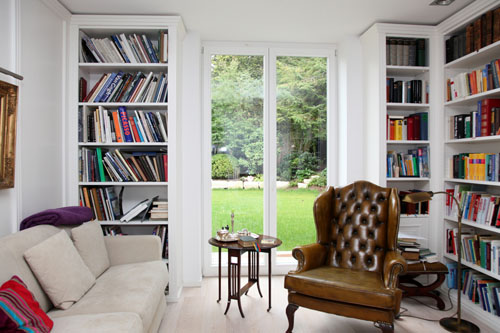 Die konsequente Dreiteilung in zwei Regalfelder in Nussholz, und einem Schrankteil mit Gleittür aus satiniertem Glas, greift die klare Linienfüh Einbauschränke und Wohnzimmer Möbel von Schreinerei Kleinert in Hanau